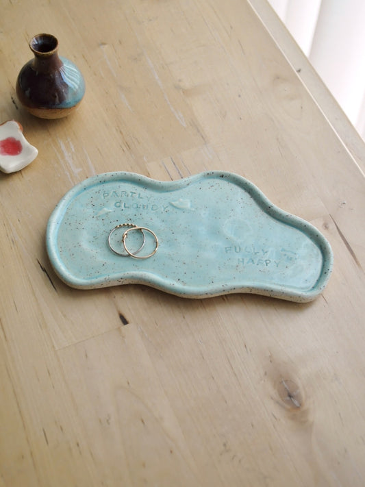 Turquoise ceramic dish with rings on a wooden surface