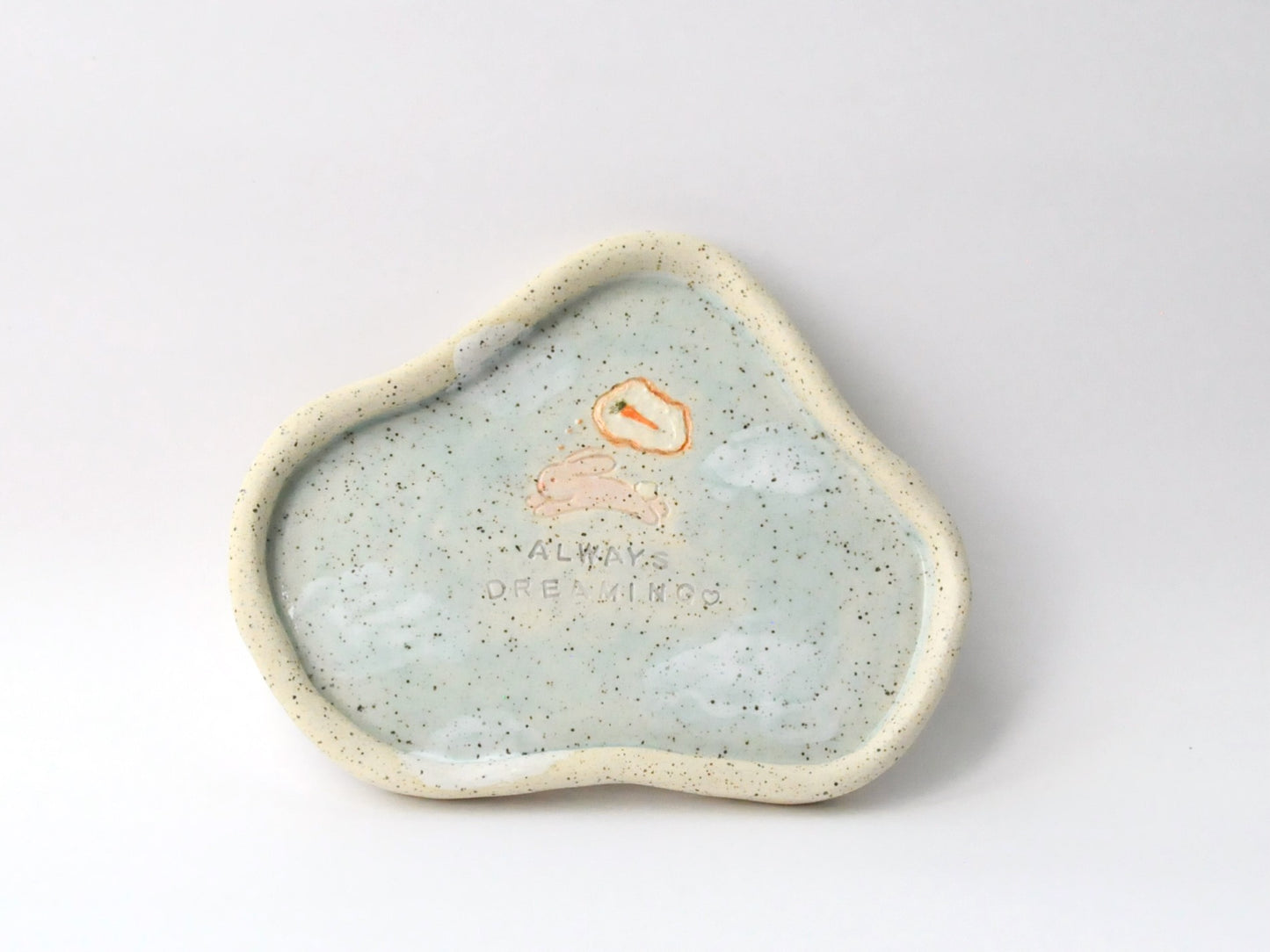 Speckled ceramic dish with a small rabbit icon on a white background