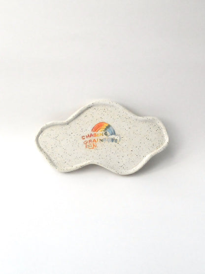 White specked trinket dish with a rainbow design on a white background