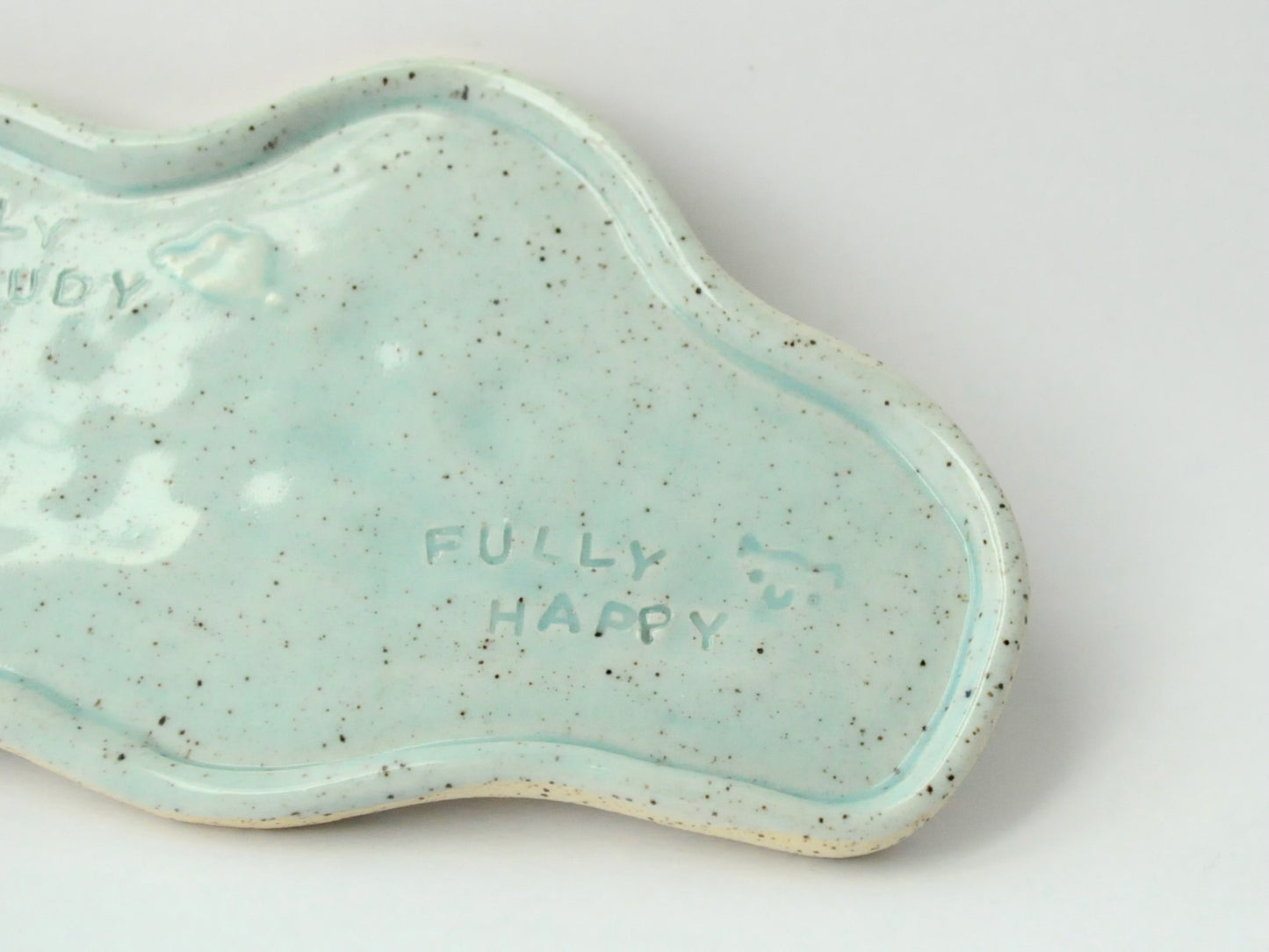 Blue ceramic dish with 'Partly Cloudy Fully Happy text on a white background