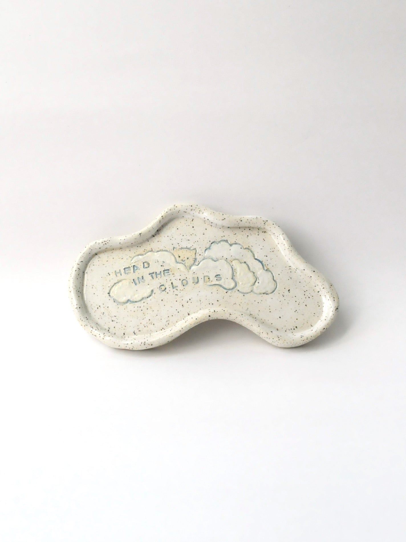 Ceramic trinket dish shaped like a cloud with 'Head in the Clouds' text on a white background