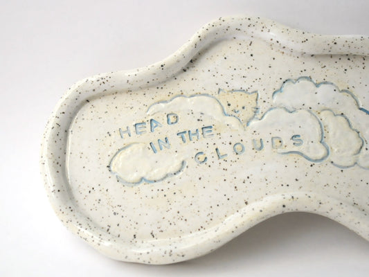 Ceramic trinket dish shaped like a cloud with 'Head in the Clouds' text on a white background