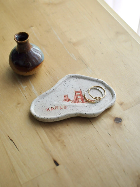 White ceramic dish with red design on a wooden surface