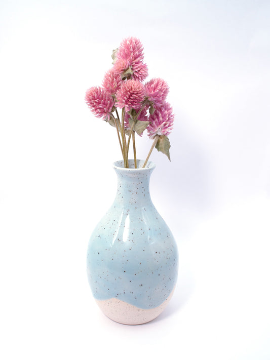 Speckled blue vase with pink flowers on a white background